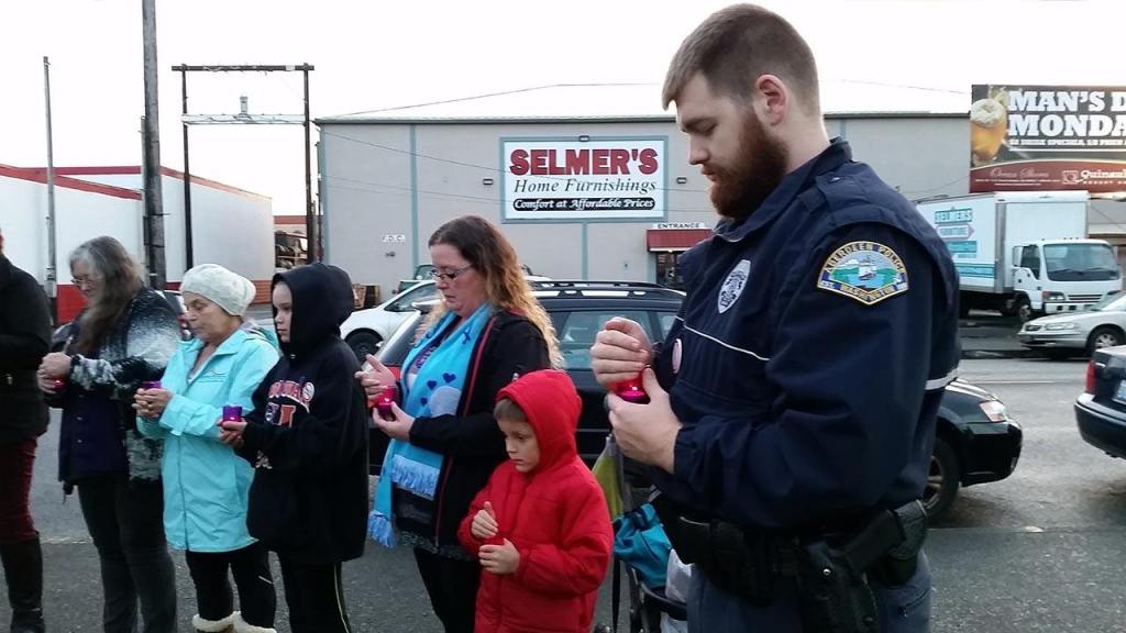 (Terri Harber/The Daily World) Aberdeen Police Officer David Tarrence, pictured in the foreground, is among participants holding candles to commemorate victims and survivors during the 4th Annual Domestic Violence Candle Light Vigil held Wednesday at Zelasco Park. He is a member of the police department&rsquo;s Domestic Abuse Response Team.