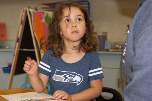 (Stephanie Morton | The Vidette)                                Makenzie Hart uses her fingertip to paint red apples on a tree as part of an assignment in Ms. Cady&rsquo;s kindergarten class on Friday.