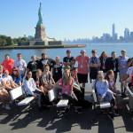 (Laura Carle/Contributed Photo) Miller Junior High School students pose for a photograph as they pass the Statue of Liberty on a ferry to Ellis Island in June 2016. Faculty advisor Laura Carle poses with the students and is seated on the far right, wearing a red shirt. Efforts have begun to plan and raise funds for the June 2018 trip to Washington, D.C. and New York City.
