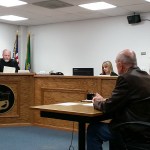 Grays Harbor County Commissioner Frank Gordon, seated in the foreground, appeared Tuesday afternoon in front of Pro-Tem Judge Chris Coker in Aberdeen Municipal Court for arraignment on the misdemeanor charge of removing or defacing political advertising. Gordon is being represented by Aberdeen attorney Jack Micheau, seated to the right of Gordon. (Terri Harber|The Daily World)