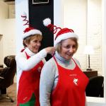 Bette Worth ties Bobbi McCracken&rsquo;s apron in the downtown office of Aberdeen Revitalization Movement. They are co-chairs of WinterFest, a local holiday event which debuts Dec. 2-3. (Terri Harber|The Daily World)