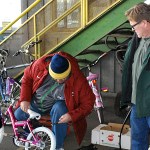 Once a child has selected a bicycle out of the 100-plus at the Bicycles from Heaven event, it is wheeled out to Lions Club volunteers who make sure the tires are properly inflated and adjust the seat for the optimum ride. Manning the air compressor at center is Bob Braden, standing to his left is Scott Berkin. DAN HAMMOCK THE DAILY WORLD