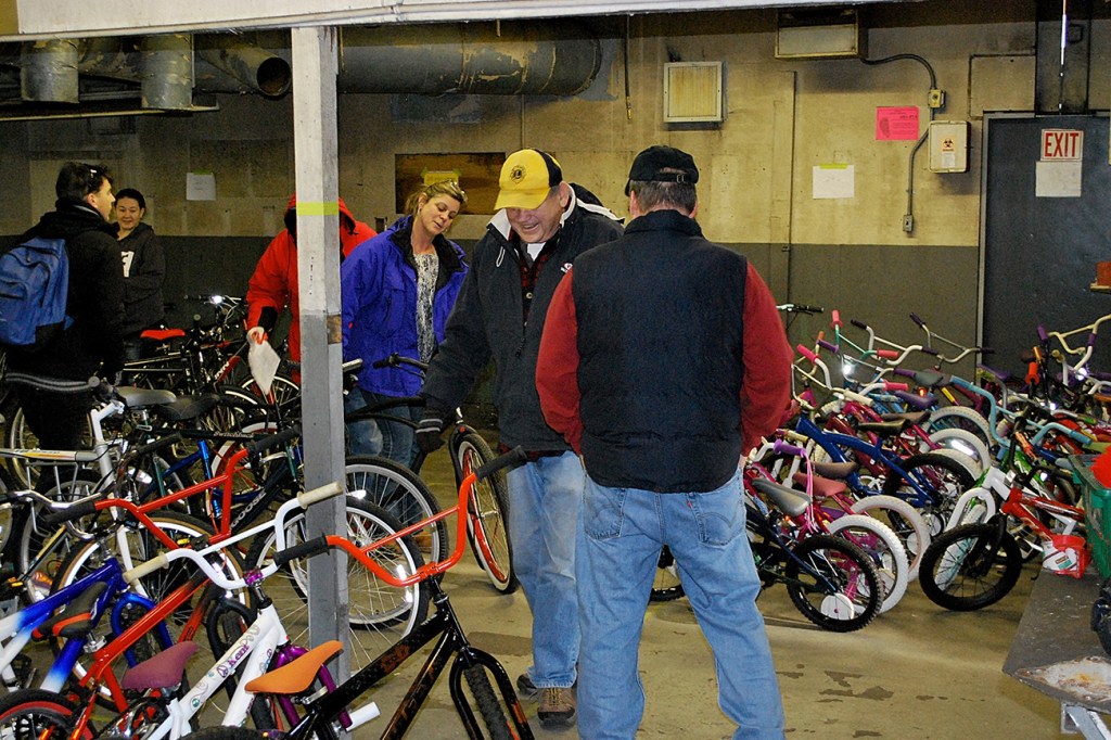 Lions Club volunteers mill among the more than 100 bicycles given away Saturday as part of their Bicycles from Heaven program. Al Waters, in the Lion&rsquo;s Club hat at center, called said of the event, &ldquo;We get to give a bike, the kids get to get a bike, the prisoners get to be part of it, it&rsquo;s a great program.&rdquo; In the red coat behind in the post is Bob Braden. Standing to Waters&rsquo; left with his back to the camera is Dennis Harke. DAN HAMMOCK THE DAILY WORLD