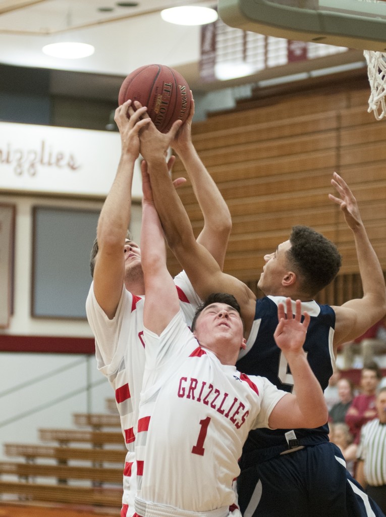 (Brendan Carl | The Daily World) Hoquiam&rsquo;s Jace Varner and Zach Spradlin (1) battle with Cascade Christian&rsquo;s Noah Wilkins for a rebound on Tuesday.