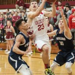 (Brendan Carl | The Daily World) Hoquiam&rsquo;s Jack Adams drives between two Cascade Christian defenders on the way to the bucket on Tuesday.