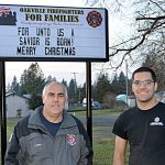 Larry Curfman and his son Jonathan stand in front of Oakville Fire Department&rsquo;s new Christmas sign. Last year a similar sign created controversy; this year the sign was placed on private property and was paid for with donations to the nonprofit Oakville Firefighters for Families organization. Jonathen and his brother Jason Curfman of Curfman Custom Fabrication and Repair donated the labor required to build the framework and install the sign.