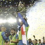 Dan Poss | Sounders FC Seattle Sounders FC Defender Román Torres hoists the MLS Cup trophy.