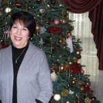 Joan Waters stands in front of one of the Christmas trees decorated inside Aberdeen Mansion, where she has lived with her husband, Al, since 1998. (Terri Harber|The Daily World)
