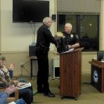 Hoquiam Police Chief Jeff Myers, left, honors Deputy Chief Don Wertanen with a section of the original Hoquiam City Jail for all his work in the recent expansion of the facility. (DAN HAMMOCK|THE DAILY WORLD)