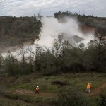 Pacific Gas & Electric crews work to move two electric transmission line towers before the Oroville Dam emergency spillway had to be used on Friday in Oroville, Calif. (Brian van der Brug/Los Angeles Times)