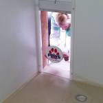 Molle Bouch applies a sticker to a window that will allow a dog to see outside a stall in the new kennel under construction at PAWS of Grays Harbor in Aberdeen. (Terri Harber|The Daily World)