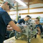 Kaden Smith, Enapa Croy and Kaylie Prieur perform routine maintenance on &ldquo;The Bullfish,&rdquo; the Fishy Business team&rsquo;s robotic competition vehicle. (SCOTT D. JOHNSTON PHOTO)