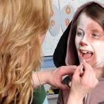 Gina Holmes, North River&rsquo;s paraprofessional for pre-K through first grade, puts the finishing touches on Kailey Greiner, who played Annie&rsquo;s dog, Sandy. Holmes supported the play in numerous ways, including &ldquo;getting the kids to their places on time and keeping the wild ones quiet backstage,&rdquo; according to Heather Johnson. She&rsquo;s also the mom of Kate Holmes, the high-school student who served as choreographer for &ldquo;Annie.&rdquo; (Photo by Kat Bryant | The Daily World)