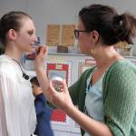 Heather Johnson reddens the lips of Destinee Greiner, who played Daddy Warbucks&rsquo; secretary, Grace Farrell. (Photo by Kat Bryant | The Daily World)