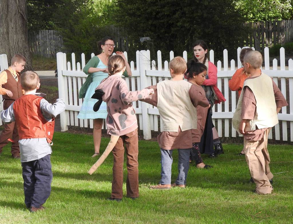 Heather Johnson leads the young cast members in calisthenics to loosen them up before curtain time. (Photo by Kat Bryant | The Daily World)