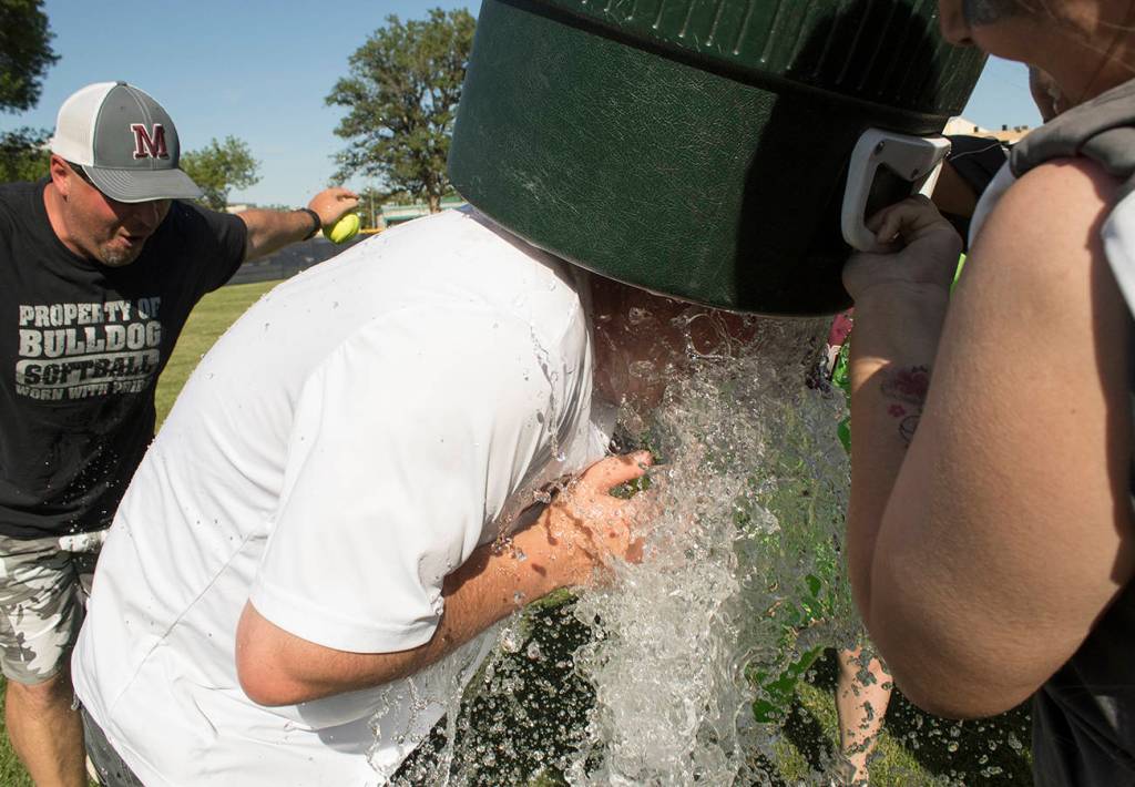 (Brendan Carl | The Daily World) Montesano players give head coach Pat Pace a water bath after the Bulldogs won the state title on Saturday.