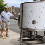 Patrick Durney, a partner in Hoquiam Brewing Co., guides a front-loader carrying a mash tun, a vessel used to combine and heat water with barley and other grains. (Photo by Kat Bryant | The Daily World)