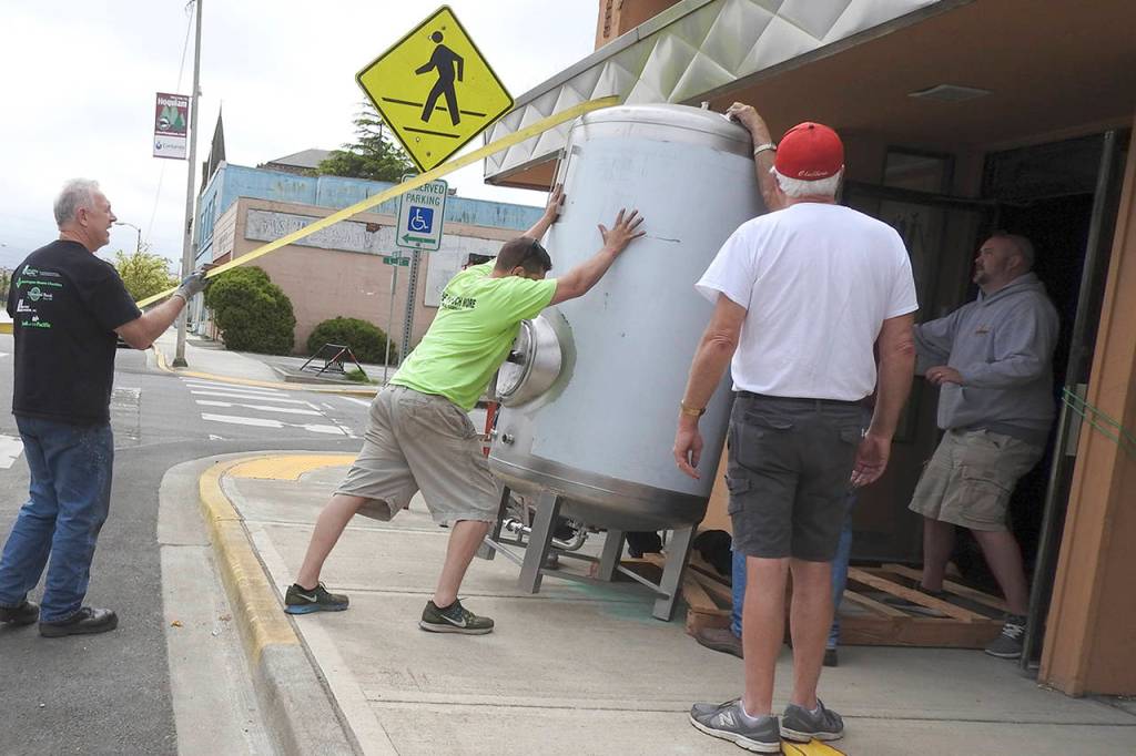Kat Bryant | The Daily World                                The brite tank (used for carbonation) had to be tilted onto its side to fit through the doors for installation. On hand to help, from left, were Jim Heikel, Brad Jones and Bob Paylor, with Hoquiam Brewing partner Patrick Durney at right.