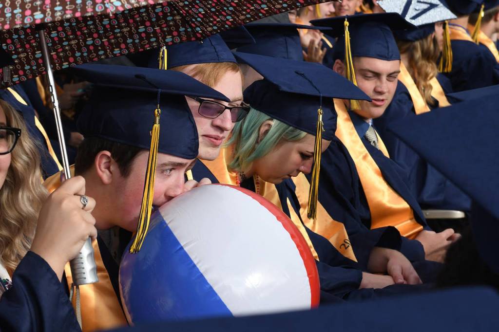 Eric Haven blows up a beach ball during Aberdeen High&rsquo;s graduation ceremony on Friday night. (Photo by Matthew Coyle)