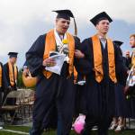 Trace Christensen and Anthony Churlin walking away with their diplomas at the end of Aberdeen High School&rsquo;s commencement ceremony on Friday night at Stewart Field. (Photo by Matthew Coyle)