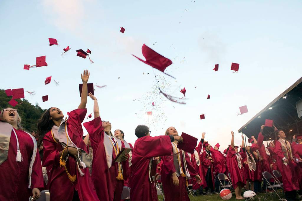 (Brendan Carl | The Daily World) Hoquiam High School&rsquo;s class of 2017 celebrates the end of their high school careers with the traditional toss of mortar boards Friday night at Olympic Stadium in Hoquiam.e Daily World)