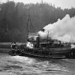 Smoke billows from the engine room of the City of Nome, soon after a blaze began on the afternoon of June 3, 1927 at the Standard Oil Dock (present day location of Lakeside Industries). The harbor tug Ranger and the larger ocean-going tug Tyee aided in crucial work by moving the City of Nome away from the fuel tanks and preventing a potentially deadly explosion. Note that the road over the bluff had not yet been constructed. In 1927 the main road in and out of Aberdeen ran along what is now the Morrison Park walkway. (Jones Photo Historical Collection)