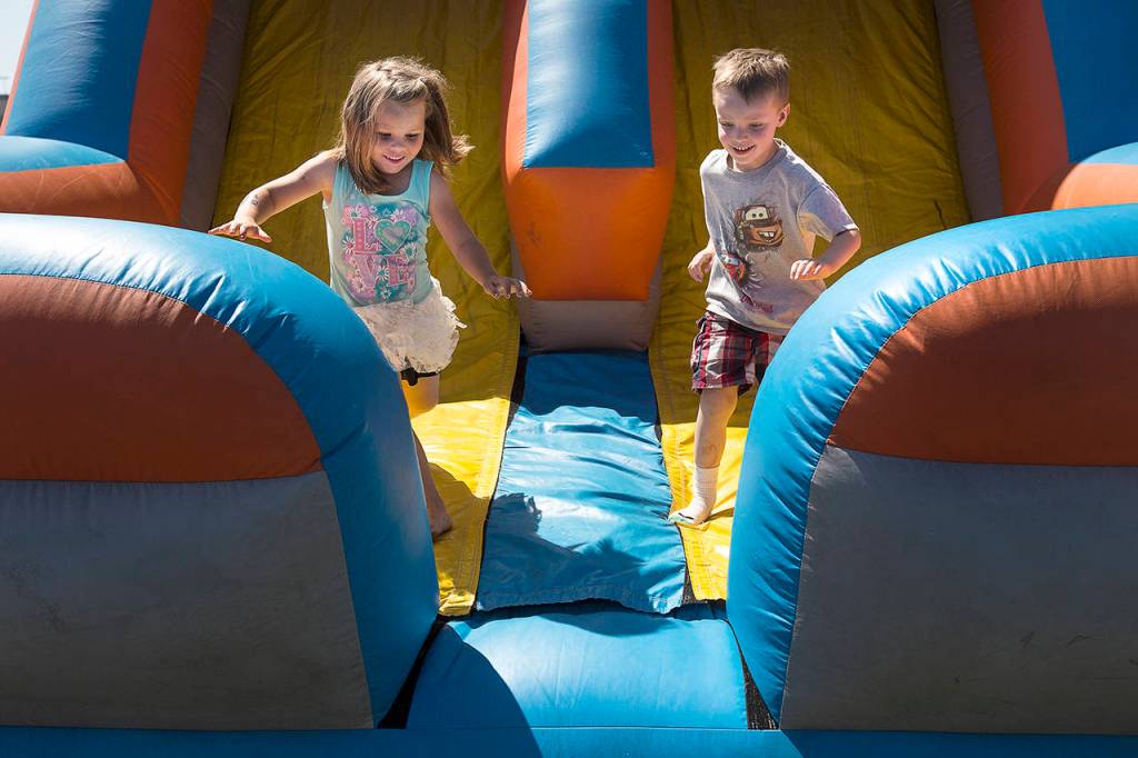 (File photo)                                Kadalynn Richardson and Emmett Johnson run out of a bounce house at the 2015 Splash Festival in Aberdeen.