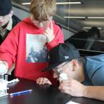 Stevens School sixth-grader Dyllan Hill, center, observes as his two Grays Harbor College lab partners, Joshua Latimer, left, and Andres Smiley study the solutions during a chemistry experiment on campus. (GHC photo)