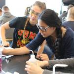 Grays Harbor College students Joyce Hoy, left, and Mariah Vogler, work with Stevens School sixth-grader Mia Gonzalez, center, during a recent field trip Stevens School students took to the GHC Schermer Chemistry lab. (GHC photo)