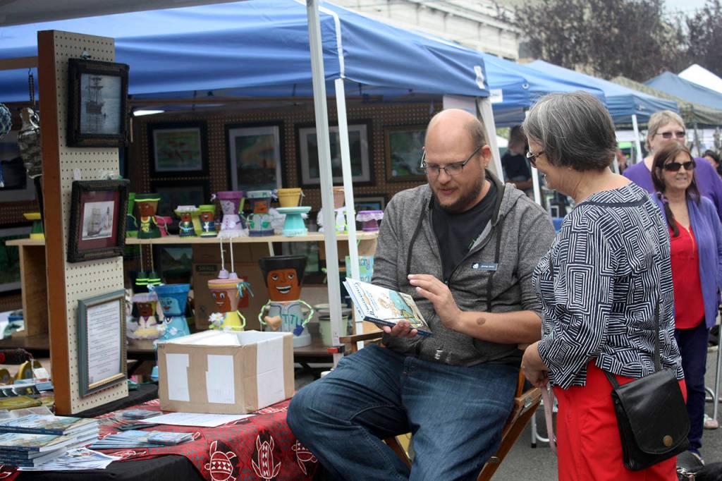 (Courtesy photo) A representative of the Grays Harbor Historical Seaport talks with a visitor at the 2016 Art Walk.