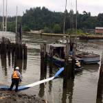 Global Diving and Salvage personnel use absorbent pads to skim oil from the water after a 42-foot commercial fishing vessel sank while moored on the Hoquiam River Wednesday. Watchstanders at Sector Columbia River received a report from Hoquiam Police Department personnel that the vessel Perwyn, with a max potential of 800 gallons of diesel aboard, had sunk and there was a sheen on the surrounding water. U.S. Coast Guard photo courtesy of Sector Columbia River Incident Management Division.