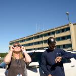 (Doug Barker | The Daily World) Laurie Wyatt of Montesano watches the eclipse from the Grays Harbor Community Hospital parking lot in Aberdeen as her son, Nolan, keeps tabs on when it would be fullest.
