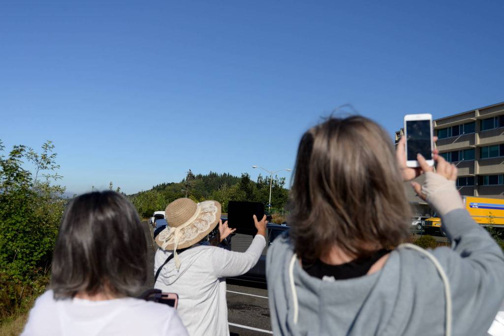 (Doug Barker | The Daily World) The partial solar eclipse is going on over their shoulders as from left, Julie Orrin, Thara Teav and Teresa Simpson, watch the eclipse in selfie mode from the parking lot of Community Hospital in Aberdeen.