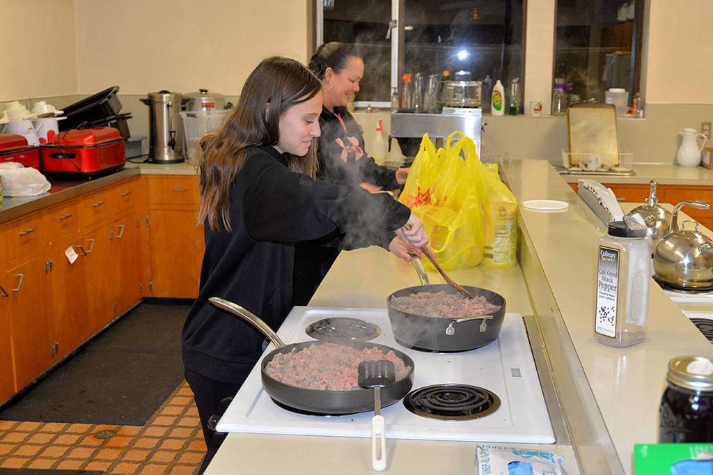 Volunteers cook meat in preparation for Friday&rsquo;s dinner at Revival of Grays Harbor in the First United Methodist Church basement. (Louis Krauss)