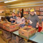 From left, volunteers Al Waters, Phyllis Granahan, Tina Miller from ASAP Business Solutions, Price Chenault and Steve Beck prepare Thanksgiving meals for 131 families at the Salvation Army food bank in Aberdeen. Those who preregistered for meals can pick them up on Monday. (Photo by Louis Krauss)
