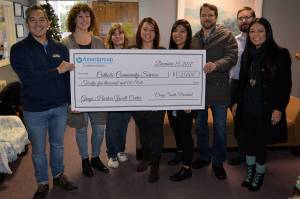 LOUIS KRAUSS | THE DAILY WORLD David Escame (left) presents a $25,000 check from Amerigroup to Grays Harbor Youth Center. The money allows the shelter to maintain daytime hours into mid-February.