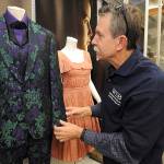 Barbara Haddock Taylor | Baltimore Sun                                 Bookstore owner John Klisavage holds a costume that was worn by actress Emma Thompson in the movie Beautiful Creatures.