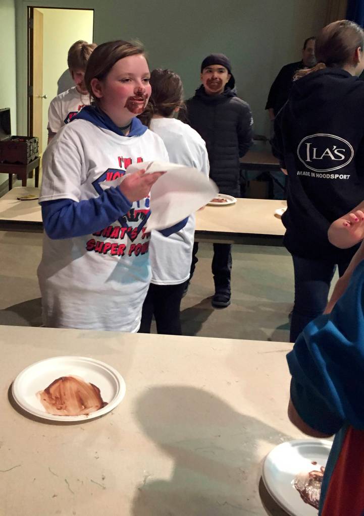 (Kat Bryant | The Daily World) Kylie Wyatt wipes her face after taking second place in the chocolate-eating contest for kids ages 10 to 15, during the 2018 Chocolate on the Beach Festival on Sunday in Pacific Beach.