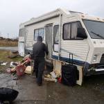 LOUIS KRAUSS | THE DAILY WORLD Brett Hussey visits a neighboring trailer home along the Wishkah River in Aberdeen. The trailer owners received city notices stating they must remove their vehicles.