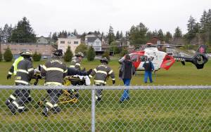 DAN HAMMOCK | THE DAILY WORLD                                Aberdeen Fire Department personnel meet a helicopter crew from Airlift Northwest as part of the Every 32 minutes program at Aberdeen High School. The helicopter landed in the soccer field adjacent to the high school parking lot and took a student who was playing a critically injured accident victim.