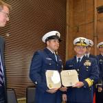 LOUIS KRAUSS | THE DAILY WORLD Coast Guard Officer Jacob Hylkema (second from left) receives a medal for heroism in Westport Friday afternoon, as U.S. Rep. Derek Kilmer watches. Hylkema volunteered to swim through 18 to 20-foot waves to rescue a drowning sailor one night in 2016.