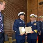LOUIS KRAUSS | THE DAILY WORLD Coast Guard Officer Jacob Hylkema (second from left) receives a medal for heroism in Westport Friday afternoon, as U.S. Rep. Derek Kilmer watches. Hylkema volunteered to swim through 18 to 20-foot waves to rescue a drowning sailor one night in 2016.