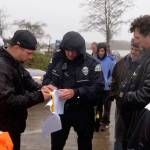 LOUIS KRAUSS | THE DAILY WORLD Sam Hutchinson (backwards black hat) shows Aberdeen Police Officer Monte Glaser the power of attorney form signed by property owner Mike Lang, allowing him to manage the property. Hutchinson decided to not tow the vehicles there after Glaser said he would have to first get a notice for eviction from the county.