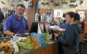 DAN HAMMOCK | TWIN HARBORS NEWSPAPER GROUP                                Englund Marine store manager Paul Foster rings up a purchase at the stores expanded location in Westport.
