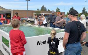 Photos by DAN HAMMOCK | THE DAILY WORLD                                A lucky angler pulls a rainbow trout out of the Cabelas trout pond at the Gateway to the Olympics Expo over the weekend.