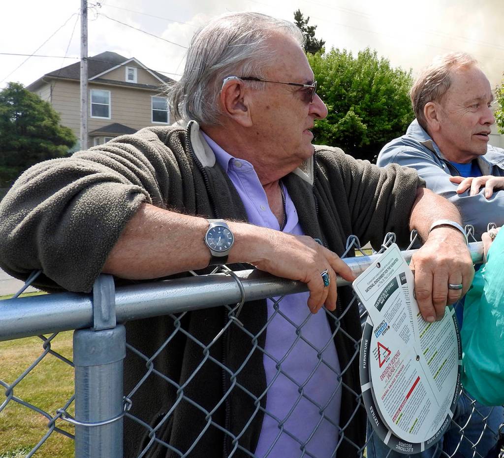 (Kat Bryant | The Daily World) Dann Sears, founding director of the Aberdeen Museum of History, holds his copy of the Emergency Response and Salvage planning tool from the National Endowment for the Humanities as he watches the fire.