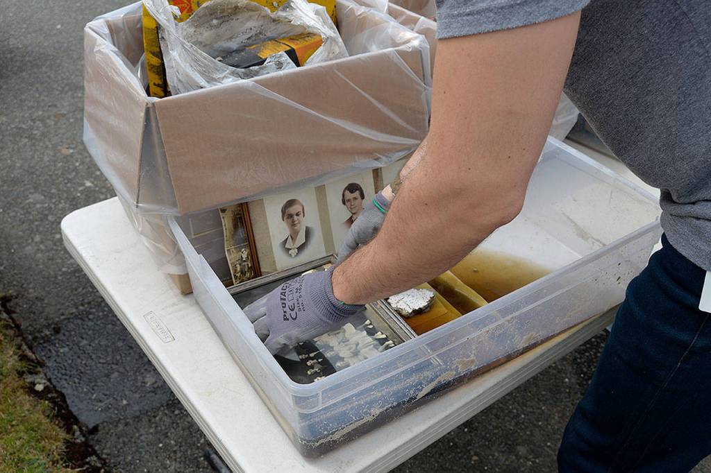 (Courtesy Dann Sears) A state archivist examines portraits recovered from the basement of the Aberdeen Museum of History. The documents in the basement received primarily just water damage.