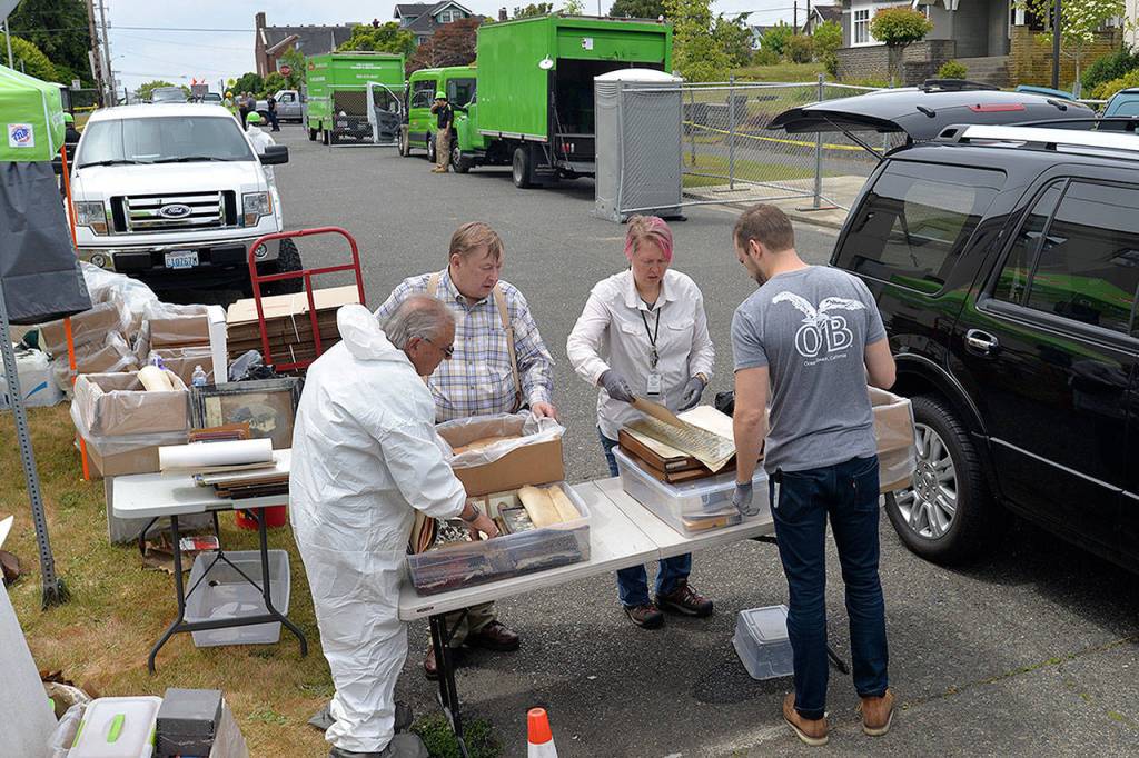 LOUIS KRAUSS | THE DAILY WORLD Dann Sears, left, looks through historic documents recovered from the archives for the Aberdeen Museum of History with help from members of the Washington State Archives.