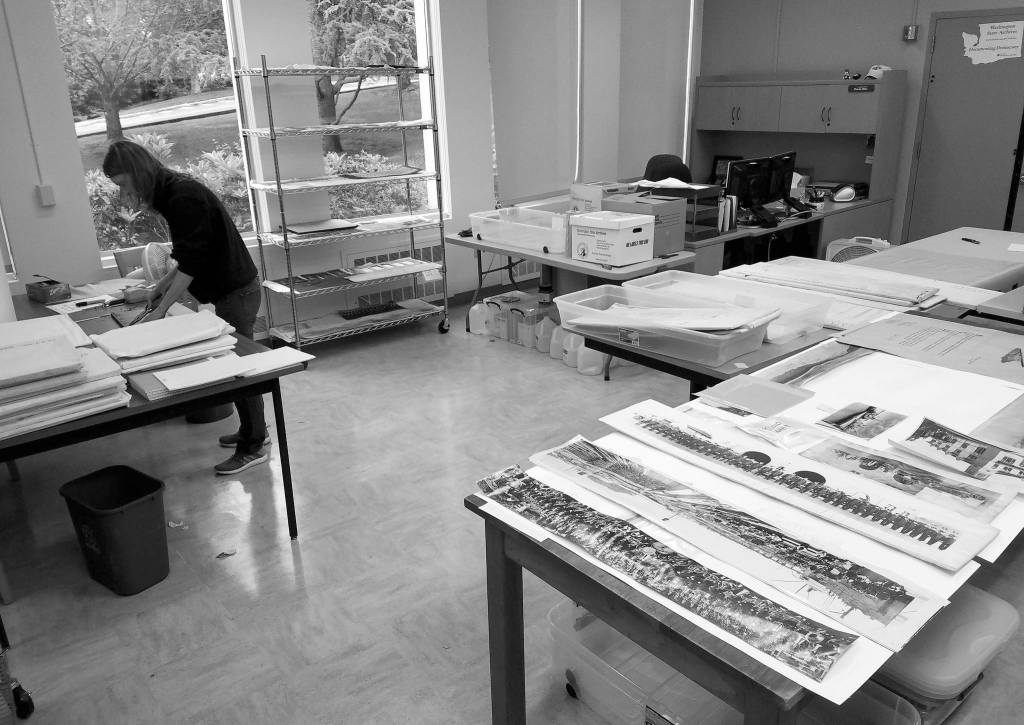 (Courtesy Washington State Archives) An archivist handles photographs recovered from the Aberdeen Museum of History archives at the State Archives in Olympia.