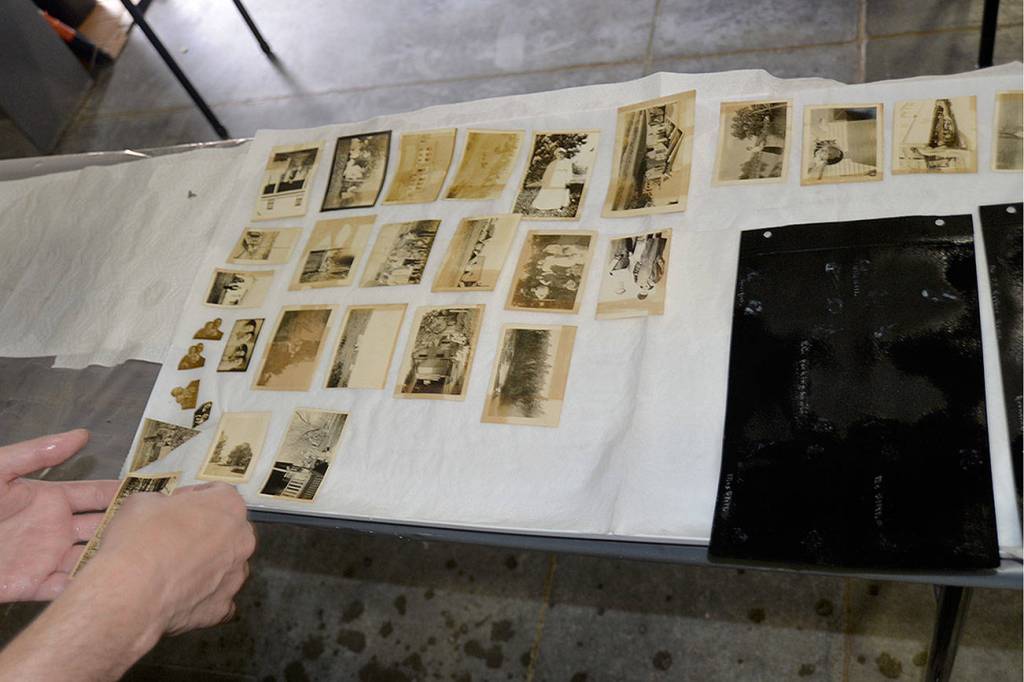 LOUIS KRAUSS | THE DAILY WORLD A volunteer lays down a photo to be dried after cleaning it at the Washington State Archives in Tumwater.
